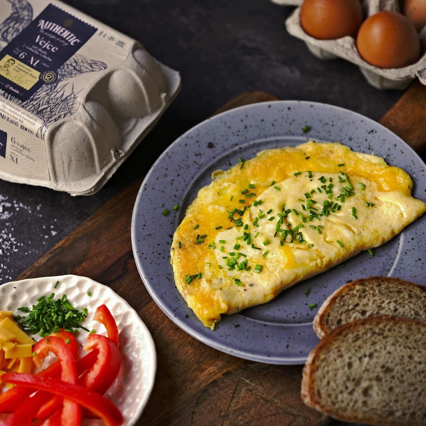 Vláčná omeleta z těch nejkvalitnějších vajec ochucená cheddarem a pažitkou - to zní jako skvělá (nejen) víkendová snídaně! 🍳 Základem omelety od @svatavacoolinarka jsou naše Authentic vejce od slepiček z volného výběhu. 🐔🥚
PS: Věděli jste, že obaly na naše vejce vyrábíme z papírových tašek, které od zákazníků vybereme zpět? ♻

Omeleta se sýrem 

3 vejce Authentic M 
1 lžička Ghí 
sůl 
čerstvě namletý pepř 
1 hrst strouhaného čedaru 
čerstvá pažitka 

Tři vejce rozklepněte do misky a rozšlehejte je se špetkou soli a čerstvě namletým pepřem. Nepřilnavou pánev zahřejte na plotýnce s mírným plamenem. Rozpusťte na ní Ghí a dokud není příliš rozpálená, nalijte do pánve vaječnou směs. Omeletu smažte jen velmi zvolna. Ze začátku vejce silikonovou stěrkou jemně míchejte, aby získala strukturu krémových míchaných vajec a uhlaďte ji. Plamen plotýnky mějte stále jen velmi slabý. Následně omeletu posypte sýrem a nechte cca minutu dojít, tak aby na povrchu omeleta měla stále strukturu míchaných vajec. Pak ji opatrně přeložte a následně přesuňte na talíř.
