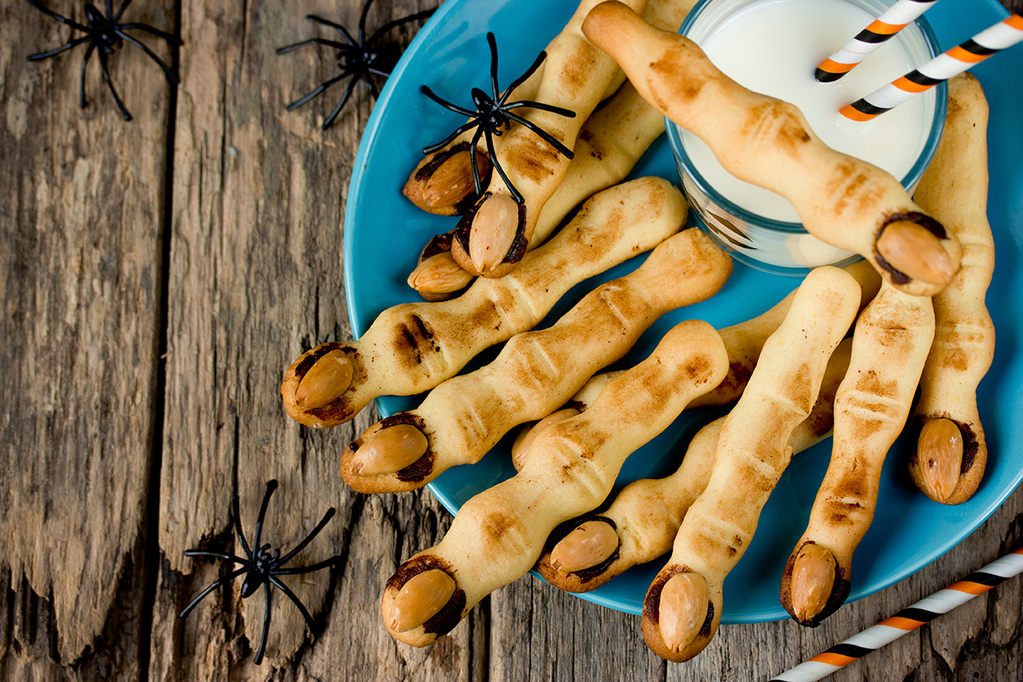 Halloween witch's fingers cookies on a plate on the old wooden background top view blank space for text